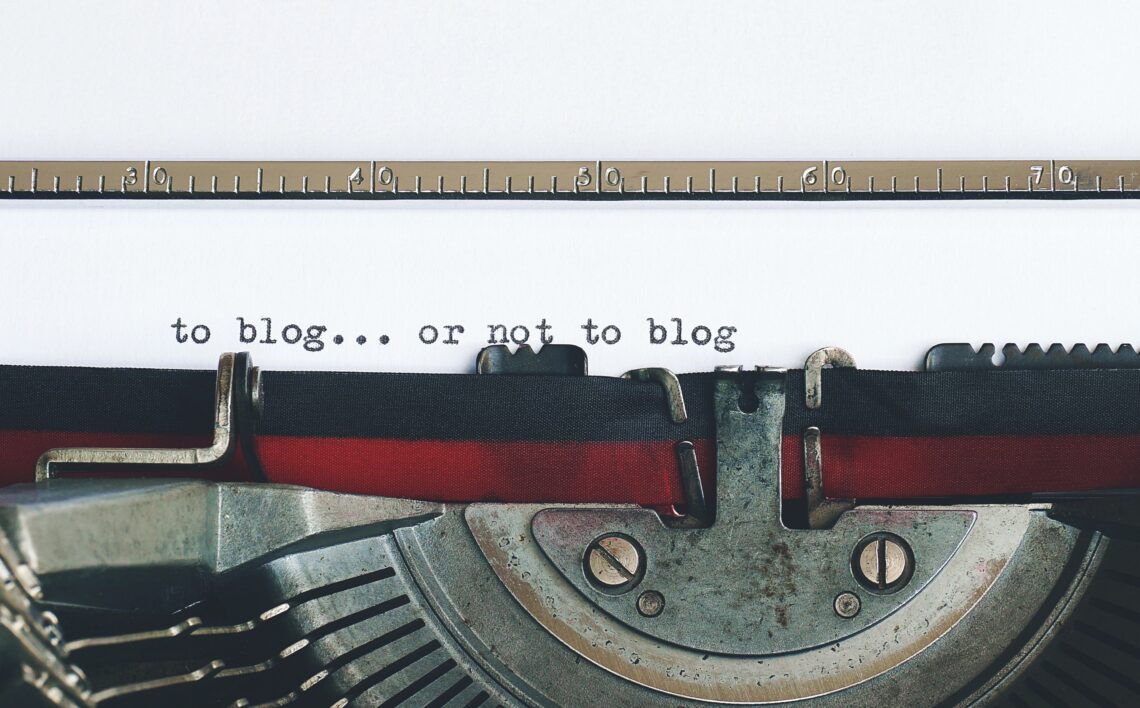 a typewriter showing the words, "to blog...or not to blog"