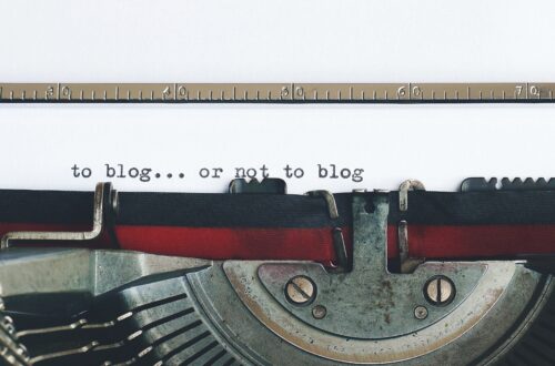 a typewriter showing the words, "to blog...or not to blog"